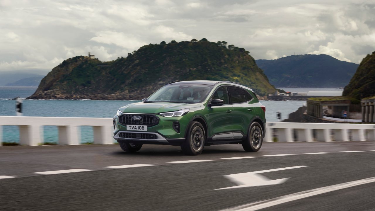Green Ford Kuga driving coastal mountain road