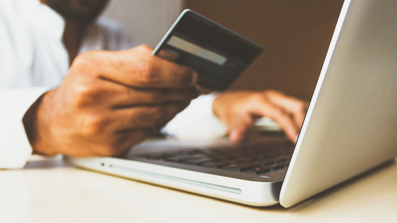 man shopping online and holding payment card