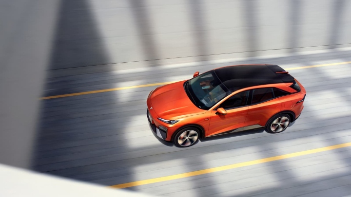 Overhead side view of an orange Changan Deepal S07 electric SUV in motion on a road