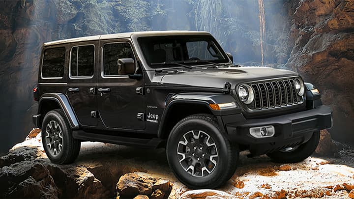Front quarter shot of a black Jeep Wrangler parked on some rocks
