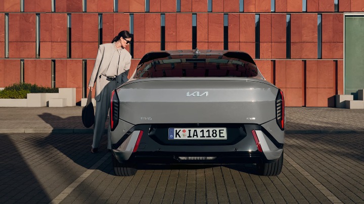 Grey Kia EV4 Exterior Rear Static with Woman