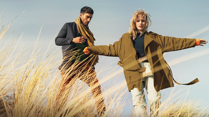 Two People Walking In A Field